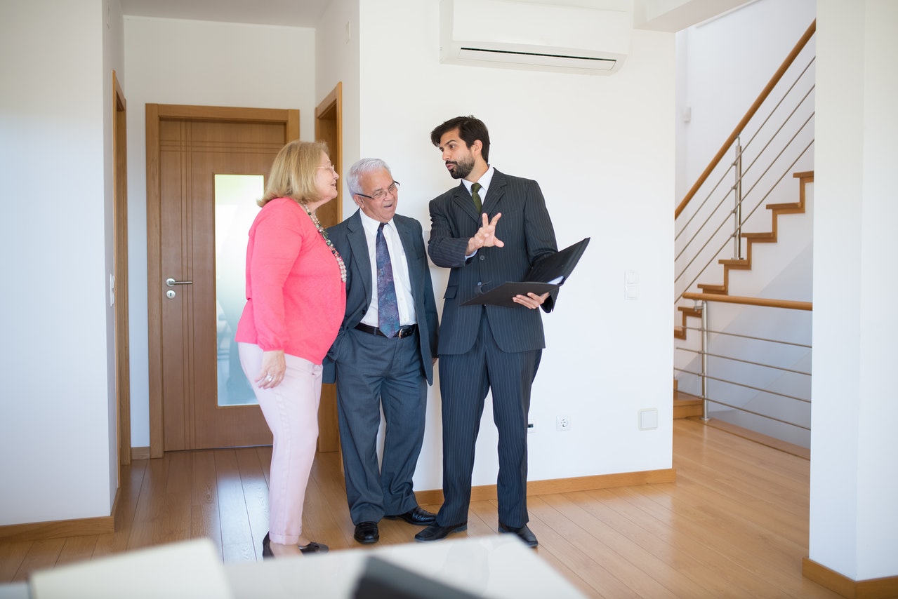 real estate agent showing home elderly couple