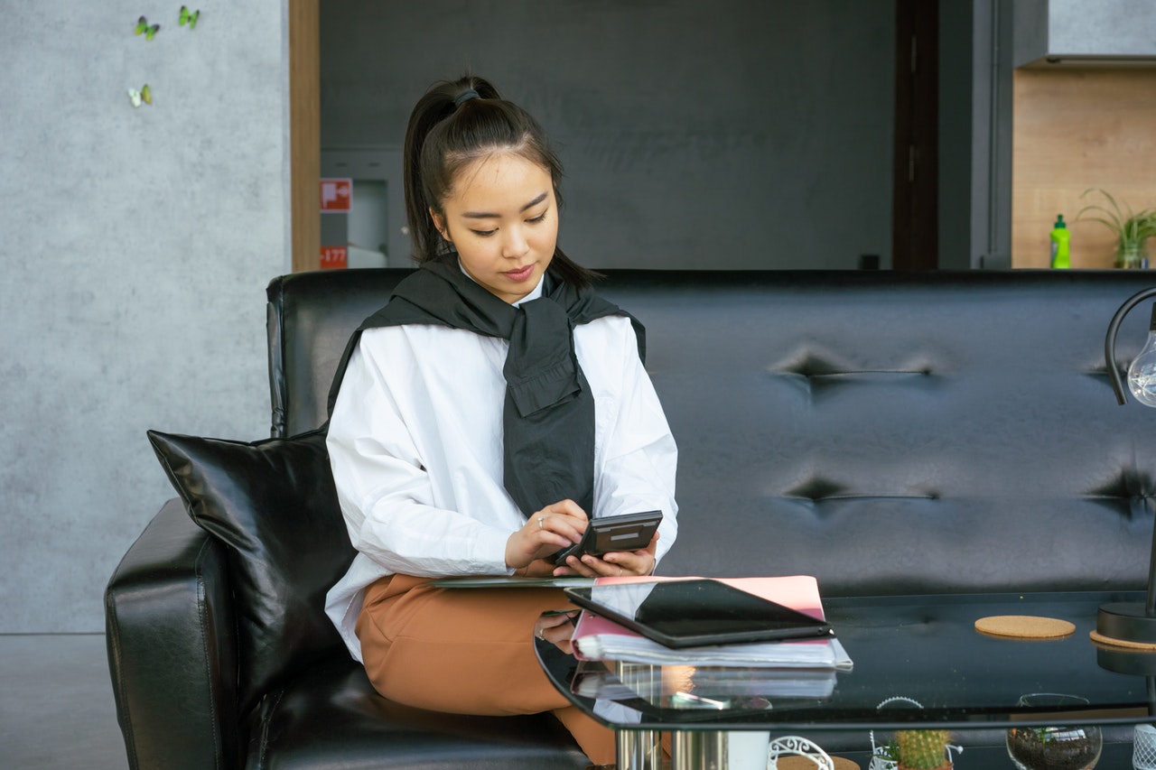 real estate agent reading woman on couch reasearching