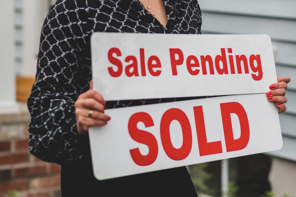person holding sold sign sold home sale pending
